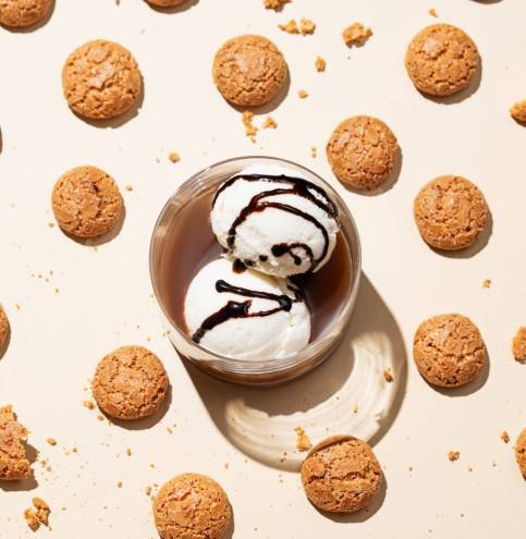 Concept pattern of affogato coffee with vanilla ice cream scoops  and espresso in a glass on a light background with amaretti cookies. Classic Italian dessert. Top view.